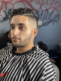 a man sitting in a barber shop with his hair cut