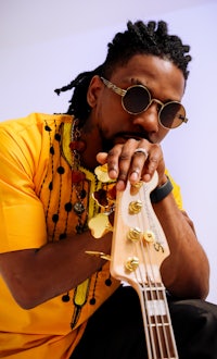 a man with dreadlocks holding a bass guitar